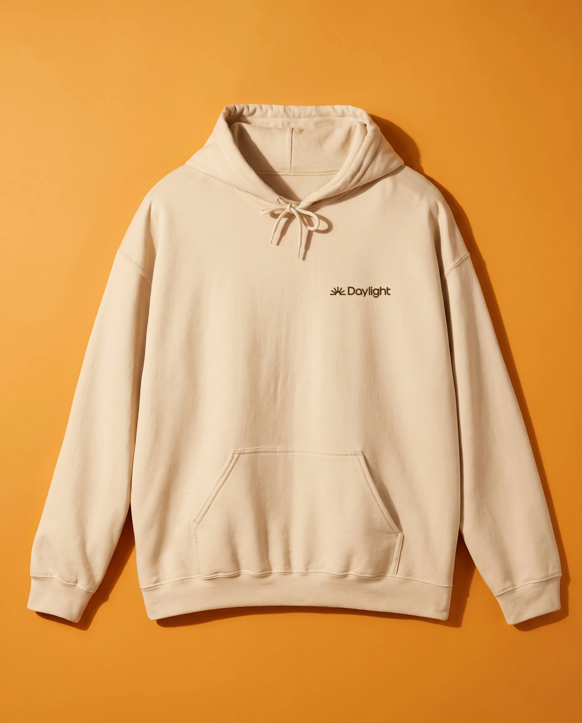 Cream hoodie with a small Daylight logo on orange