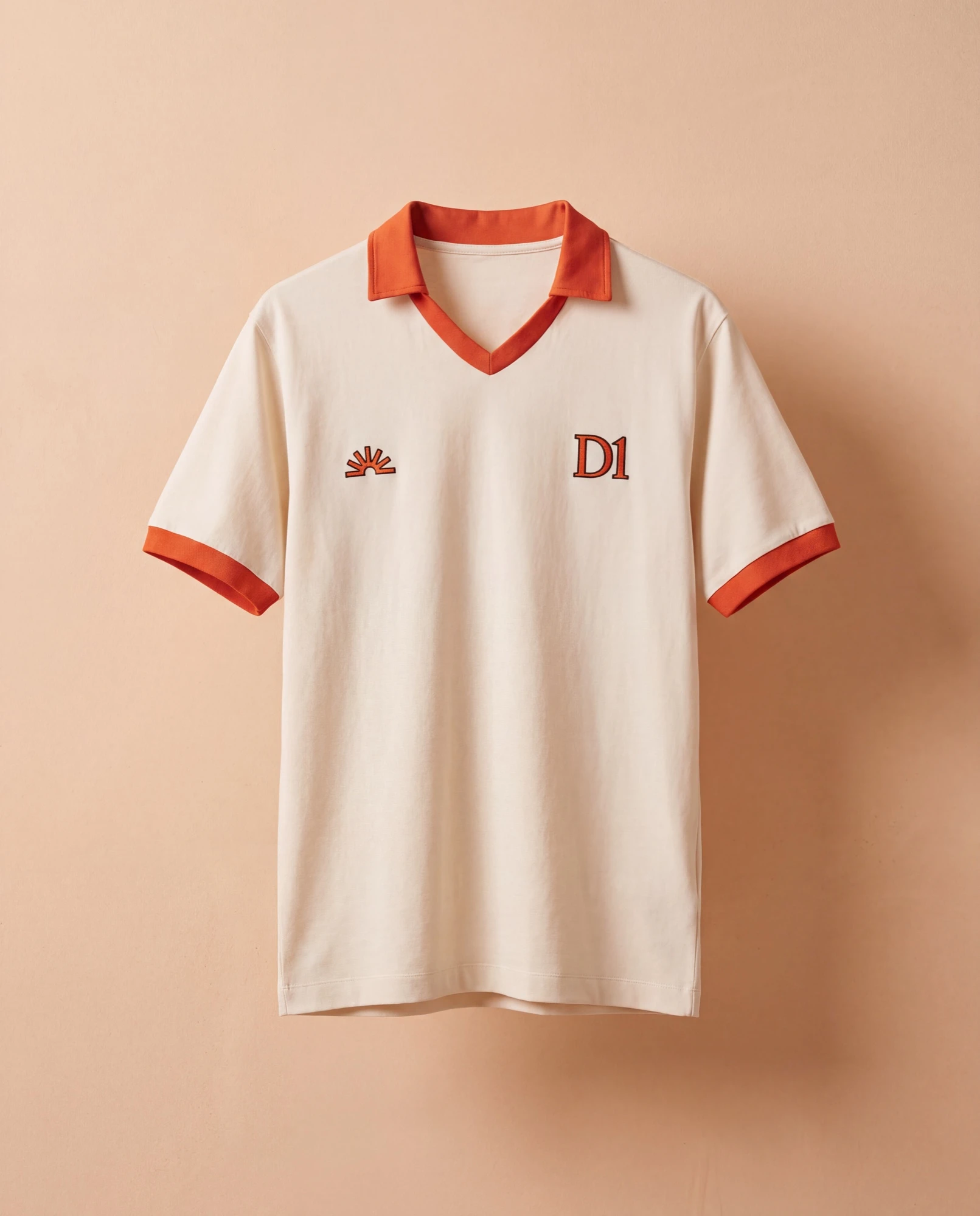 Cream polo with an orange collar on a peach background