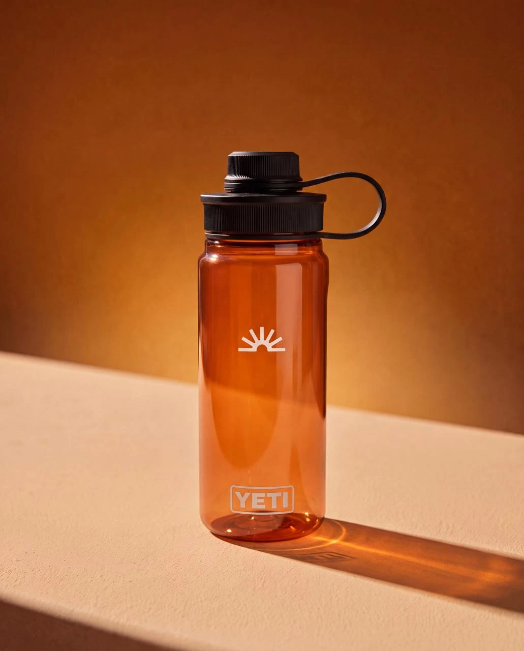 Translucent orange water bottle with the Daylight sun logo